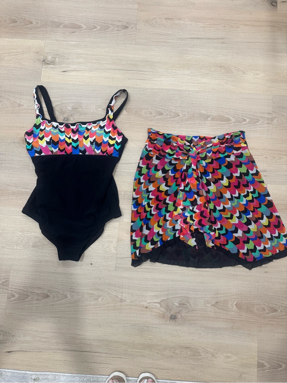 Matching one piece swim suit with matching cover up skirt.